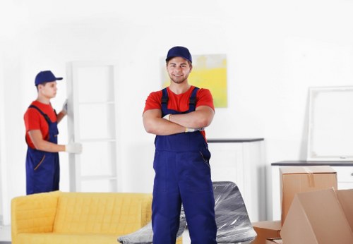 Professional movers organising packed boxes in a Holland Park property